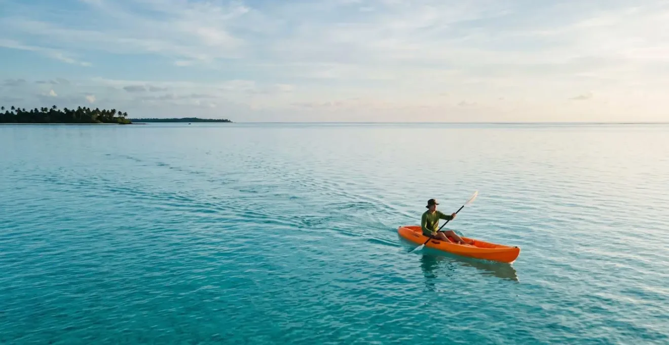 Kayaker paddling on calm turquoise water during surface interval after scuba diving